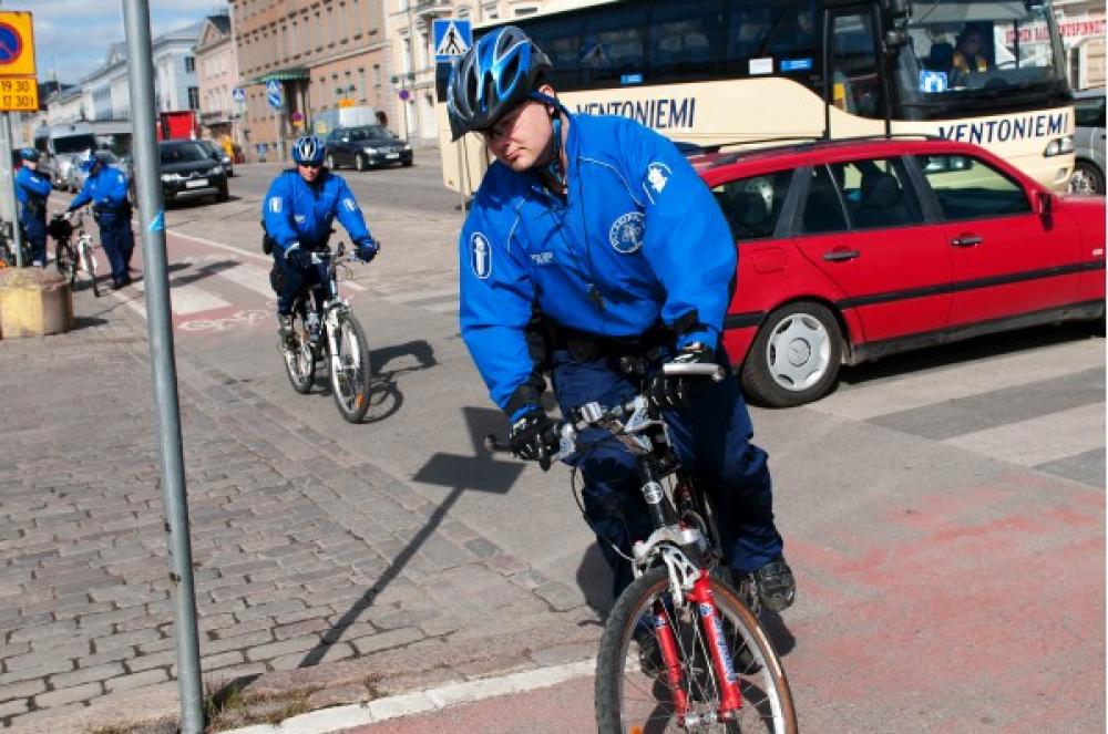 Poliisi pyöräilee Helsingissä.